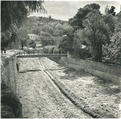 Αθήνα 1940. Η κοίτη του Ιλισσού με το γεφυράκι που πήγαινε κάποτε στο παριλίσιο θέατρο ΠΑΡΑΔΕΙΣΟΣ. Στο βάθος, ο λόφος του Αρδηττού και το σπίτι του Κωνσταντίνου Μαζαράκη - Αινιάν.