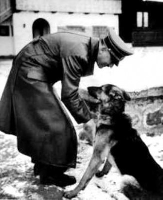 ca. 1940s, Berghof, Germany --- Adolf Hitler plays with a young German Shepherd dog at Berghof. --- Image by © CORBIS