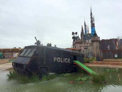 Dismaland. Η σκοτεινή “Disneyland” όπως τη φαντάστηκε ο θρυλικός γκραφιτάς Banksy. Καμένο κάστρο, νεκρή Σταχτοπούτα και μια λίμνη γεμάτη πρόσφυγες