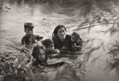 Δύο μάνες με τα παιδιά τους προσπαθούν να περάσουν το ποτάμι για να σωθούν από τους βομβαρδισμούς στο Βιετνάμ. Ο φωτογράφος που τους δώρισε τα χρήματα που πήρε ως βραβείο, σκοτώθηκε στο πεδίο της μάχης