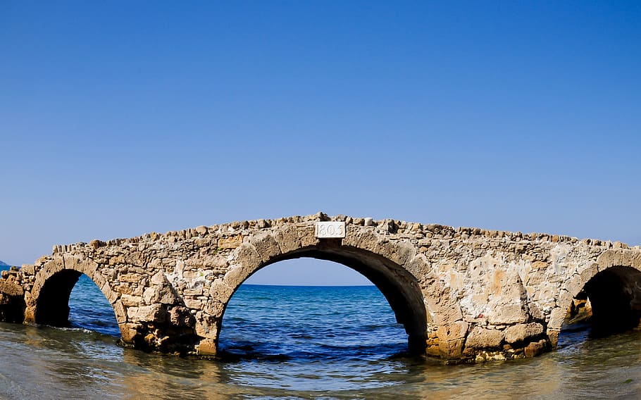 Το γεφύρι κάποτε ήταν μέρος του παραλιακού δρόμου που χάθηκε. Το έφτιαξαν οι Βενετσιάνοι με “γερακόπετρες” και εξακολουθεί να στέκεται μέσα στη θάλασσα  